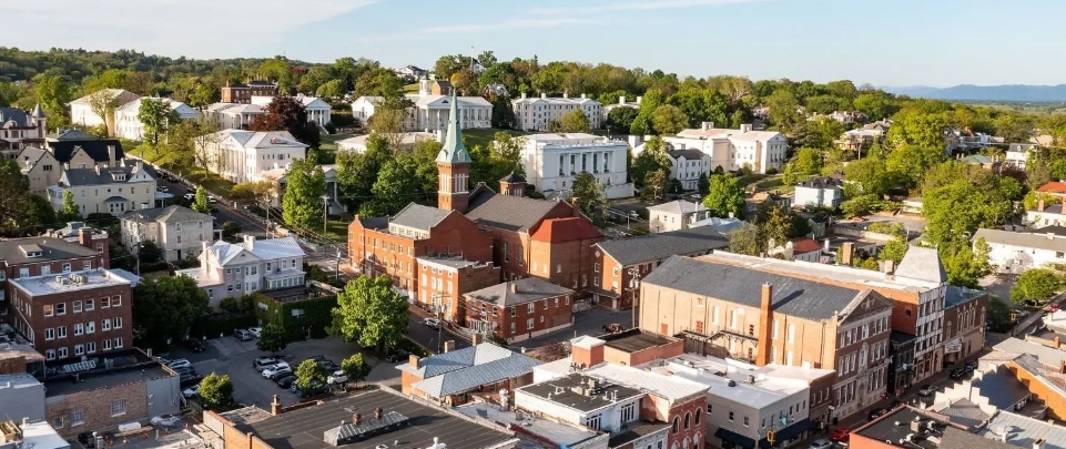 An aerial view of a church with a tall steeple and surrounding buildings in staunton virginia.