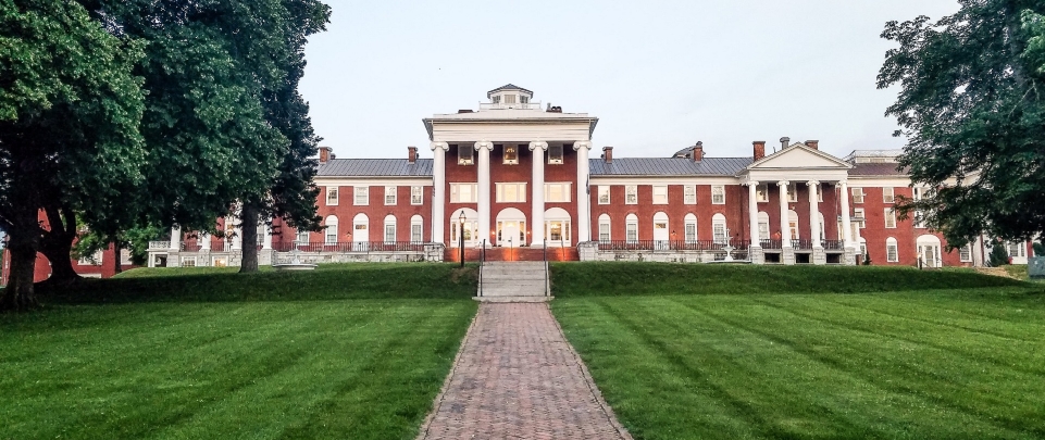 A brick path surrounded by grass leads to the front entrance of the blackburn inn in staunton virginia.